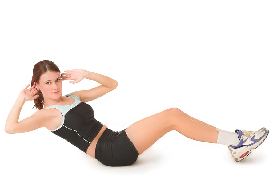 A woman in gym clothes, doing sit-ups