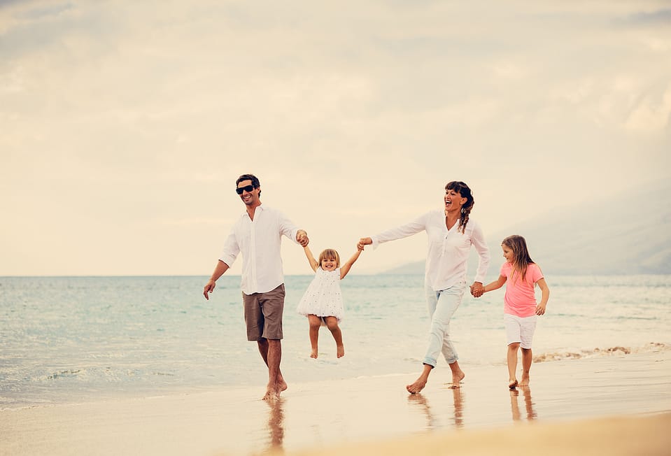 Happy Young Family have Fun Walking on Beach at Sunset